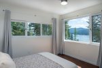 Bedroom 4 on the main floor of the home, features a queen size bed, ensuite & incredible views.